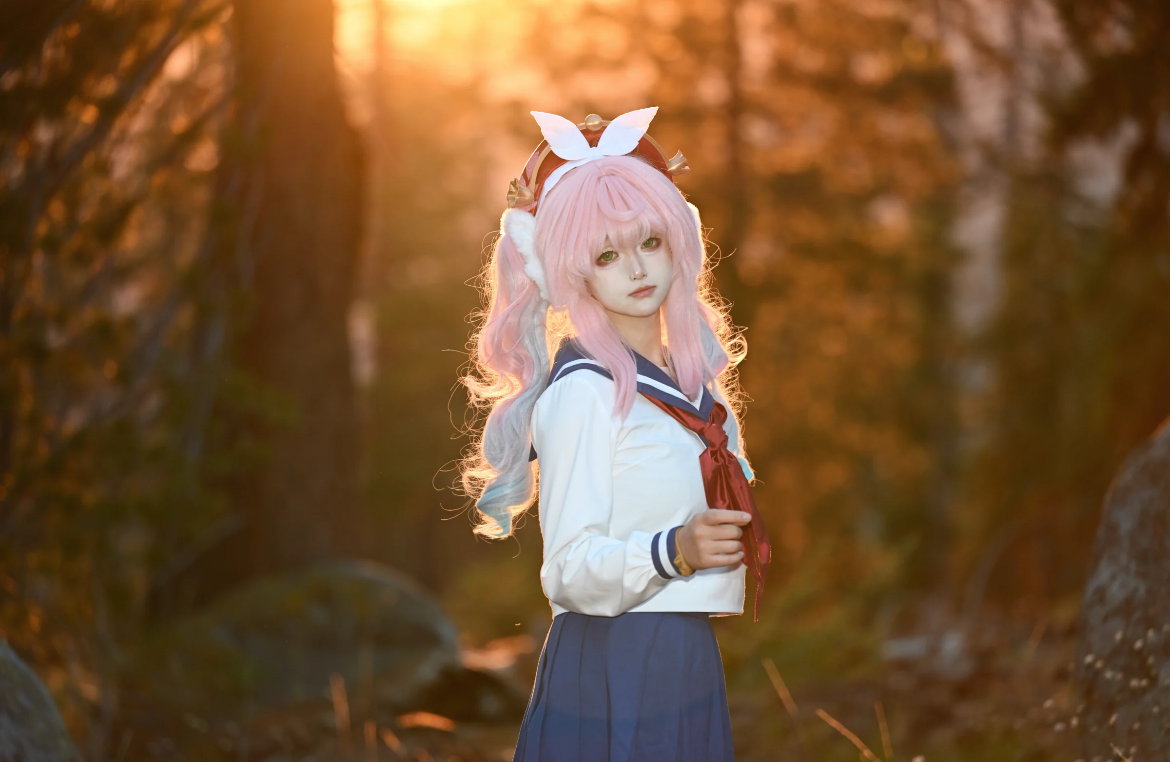 Cosplayer with a pink wig and sailor-style costume in warm evening light