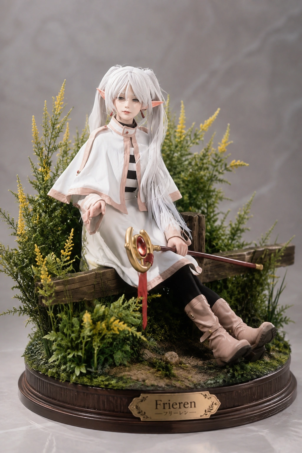 White-haired elf character figure holding a staff on a planted display base